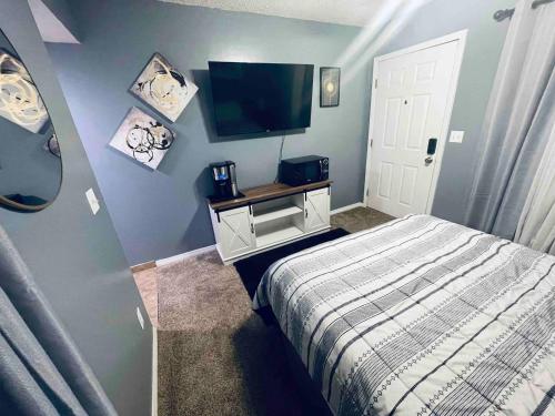 a bedroom with a bed and a flat screen tv at Lakeside Stay For Two By Wet Feet Retreats in Four Seasons