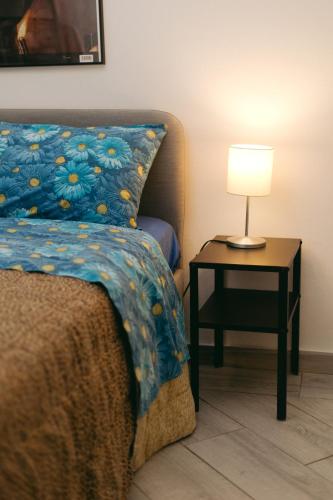 a bedroom with a bed and a table with a lamp at Casa Luba in Lucca