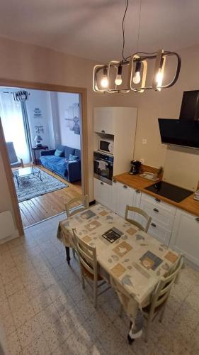 une cuisine et une salle à manger avec une table et des chaises dans l'établissement Le Saint Martin, à Fort-Mahon-Plage