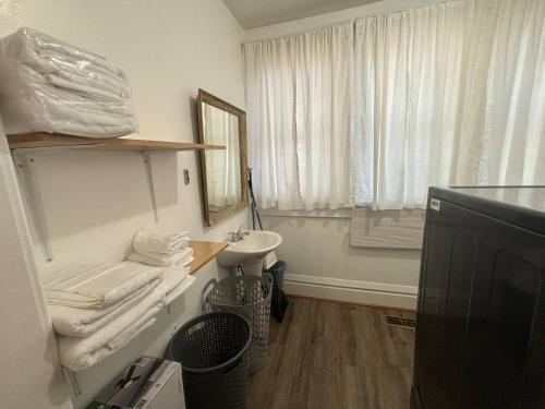 a white bathroom with a sink and a mirror at 2BR 1st floor suite close to ISU in Terre Haute