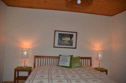 a bedroom with a bed with two lamps on it at Apartment Grössenberg in Weißkirchen in Steiermark