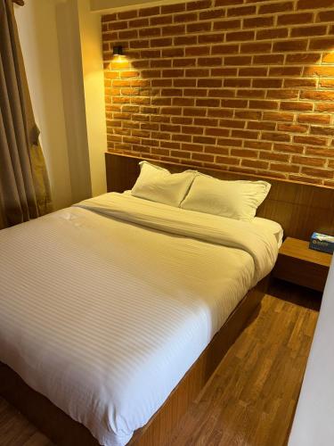 a bed in a room with a brick wall at Mandah Heritage Home in Kathmandu