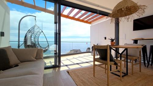a living room with a table and a view of the ocean at Oasis House in São Roque