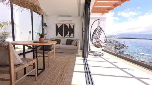 a living room with a table and a view of the ocean at Oasis House in São Roque