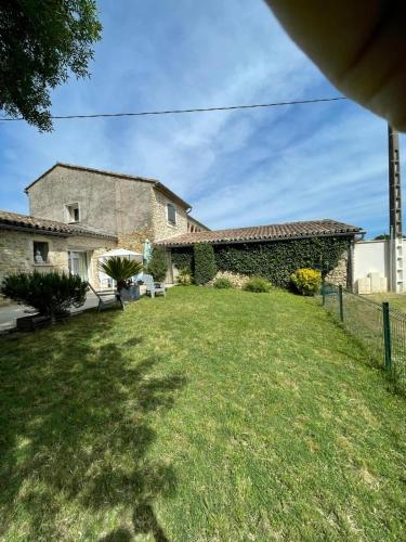a stone house with a yard with a fence at Mas en Pierre "entre Gard et Ardèche" avec jardin in Saint-Victor-de-Malcap