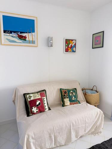 - un canapé blanc dans le salon avec des oreillers dans l'établissement studio sur l'eau avec plage privée, à Six-Fours-les-Plages