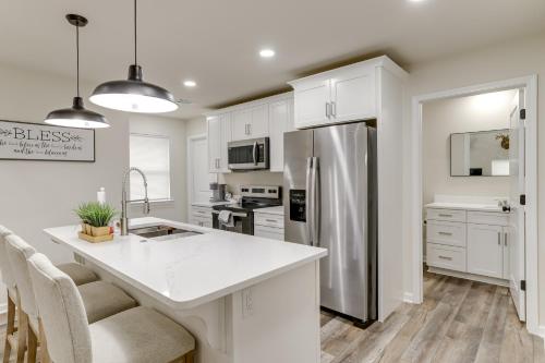 a kitchen with white cabinets and a stainless steel refrigerator at Walk to River Newly Built Home in Heber Springs! in Heber Springs