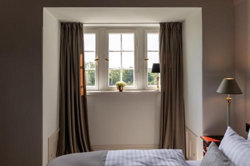 a bedroom with a bed and a window at Schlosshotel Neustrelitz in Neustrelitz