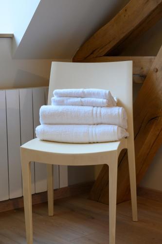 une pile de serviettes assises sur une chaise blanche dans l'établissement 6 - Seigneurie Fouquet - Cocagne, au Palais