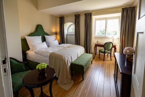 a hotel room with a bed and a table and chairs at Schlosshotel Neustrelitz in Neustrelitz