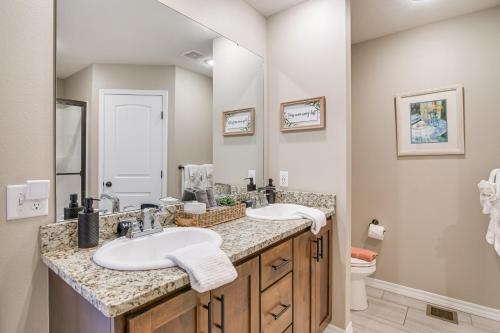 a bathroom with two sinks and a toilet at Ozark Home Pool Access, Deck and Fenced Yard in Ozark