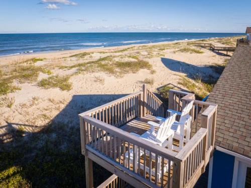 een balkon met twee witte stoelen op het strand bij Oceanfront Views Private Beach Access and Hot Tub in Nags Head