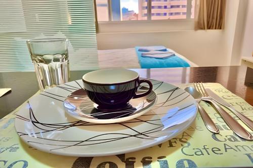 a coffee cup on a plate on a table at Exuberante studio Bem no centro da Cidade in Curitiba