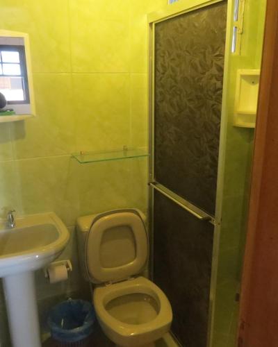 a small bathroom with a toilet and a sink at Pousada Brasil Tropical in Ilha do Mel