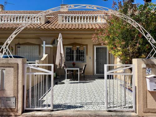 una puerta a una casa con una mesa y una sombrilla en Casa Moolio, en Los Alcázares