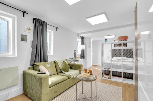 a living room with a couch and a bed at Detached & Secluded Bungalow, Northern Line 20m to Central London, Marathon and Events ready in Colindale