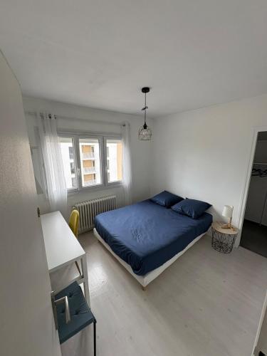 une chambre avec un lit bleu et une fenêtre dans l'établissement Maison spacieuse proche de Caen, à Colombelles