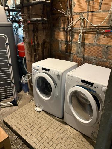 Deux lave-linge sont assis l'un à côté de l'autre dans l'établissement Maison spacieuse proche de Caen, à Colombelles