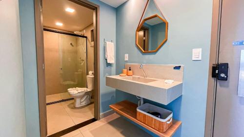 a bathroom with a sink and a toilet and a mirror at Flat FM20 Cabo Branco Ocean - By Almare in Tambaú