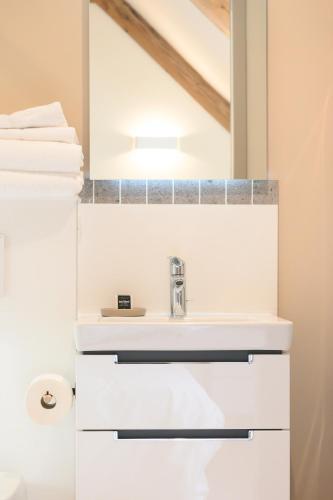 une salle de bain avec un lavabo et un miroir dans l'établissement 3 - Seigneurie Fouquet - Miscou, au Palais