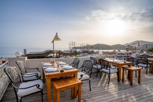 a restaurant with tables and chairs on a deck at Jade Residence in Oludeniz
