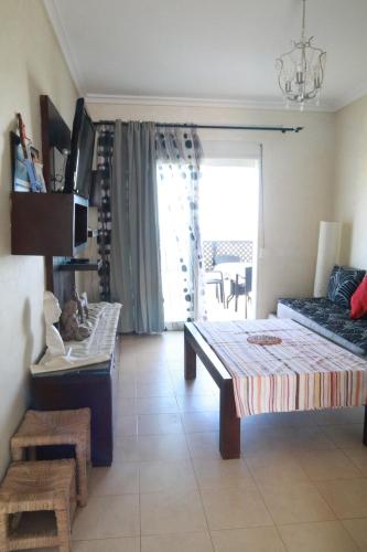 a bedroom with a bed and a couch and a window at Sea View Apartment in Cabo Negro