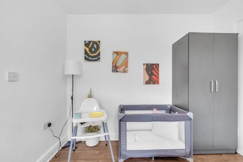 a small room with a bed and a cabinet at The Connected Garden Flat - Parking, Work & Play, 3x in Colindale