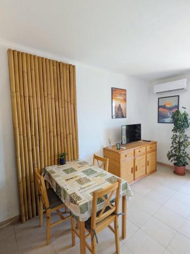 une salle à manger avec une table et une télévision dans l'établissement Séjour à Valras T1 Vue sur Mer - 50m centre et mer, à Valras-Plage