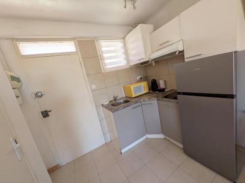 une petite cuisine avec un évier et un réfrigérateur dans l'établissement Séjour à Valras T1 Vue sur Mer - 50m centre et mer, à Valras-Plage