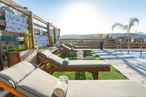 a row of chaise lounges on a patio next to a pool at RELAXING POOL HOUSE IN LAGONISI 1 in Kalívia Thorikoú