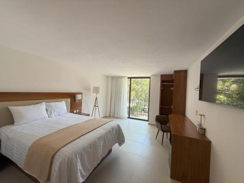 a bedroom with a bed and a desk and a window at Hotel Casa Kavia Vallarta in Puerto Vallarta