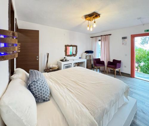 a bedroom with a large white bed with a couch at Sazlı Shores in Ayvacık