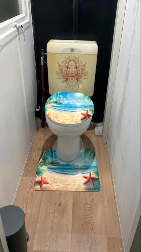 une salle de bain avec des toilettes avec un siège peint dans l'établissement Mobilhome - Aiguebellette 73, à Novalaise