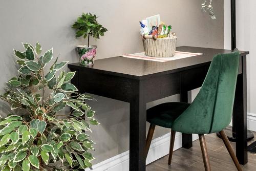 a desk with a green chair and some plants at Stylish 2 Bedroom Condo Downtown Ottawa in Ottawa