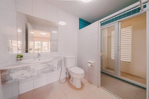 une salle de bains blanche avec toilettes et lavabo dans l'établissement บ้านทะเลสำราญ by May, à Cha Am
