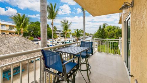 a balcony with a table and chairs and palm trees at Port Largo Villas Escape 5A in Key Largo