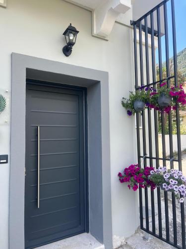 a black garage door on a white house with flowers at Vista Mare in Ýpsos