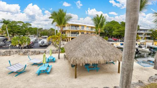 a group of chairs and a straw umbrella on a beach at Port Largo Villas Escape 5A in Key Largo
