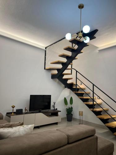 a living room with a staircase and a tv at Vista Mare in Ýpsos
