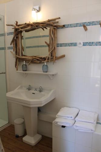 a bathroom with a sink and a mirror and towels at Les loges de la suite in Prades