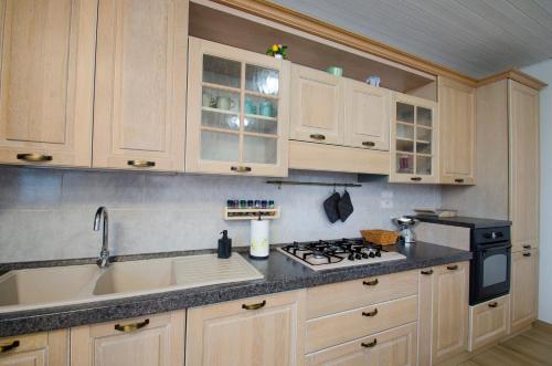 a kitchen with wooden cabinets and a stove top oven at Villa Asia, private villa with pool in Panicarola