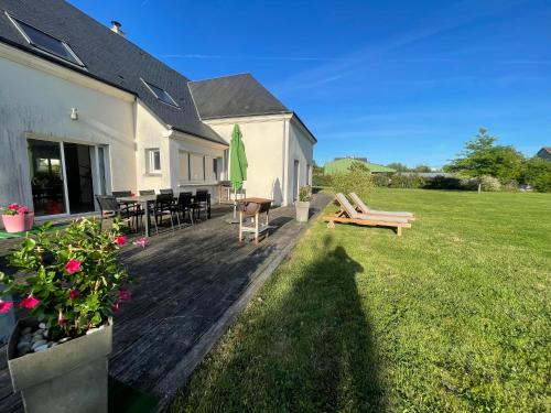 a backyard with a deck with a table and a bench at Maison à louer in Yèvres