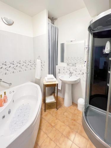 une salle de bain blanche avec une baignoire et un lavabo dans l'établissement La Maison d'Alienor Les Beauregards, à Chablis