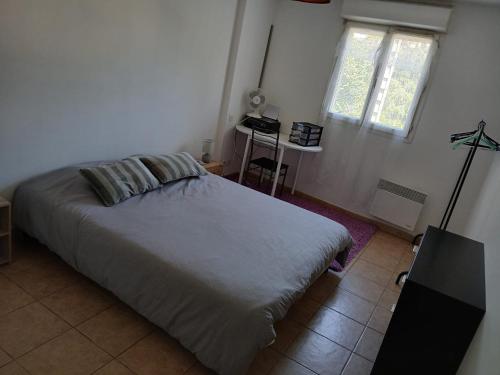 une chambre avec un grand lit et une fenêtre dans l'établissement Agréable T2, avec terrasse, à La Seyne-sur-Mer
