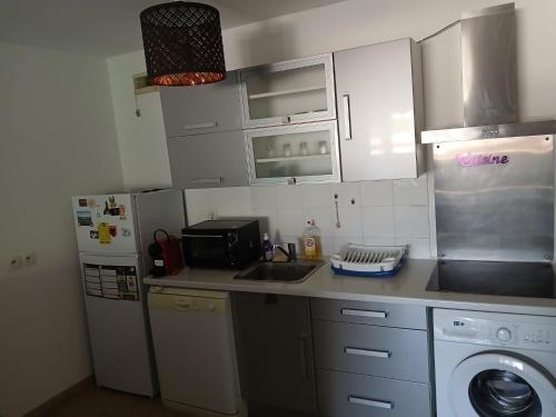 une petite cuisine avec un évier et un réfrigérateur dans l'établissement Agréable T2, avec terrasse, à La Seyne-sur-Mer