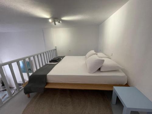 a bed with white sheets and pillows in a room at Spanos Suites - Panteli in Panteli