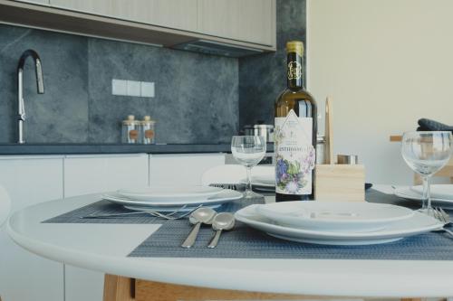 a white table with a bottle of wine and glasses at Modern Villa with Private Pool - Olive Grove in Ferma