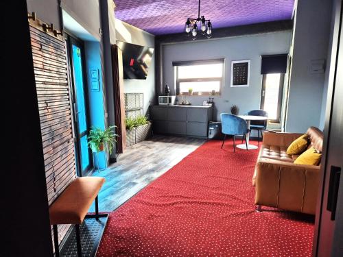 un soggiorno con divano e tappeto rosso di Mogosoaia High Living Garden a Chitila