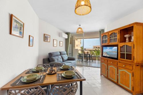 a living room with a dining table and a television at Apolo XI, Calpe, Modern Holiday Apartment, Sea view, Pool, 100m to Beach! in Calpe