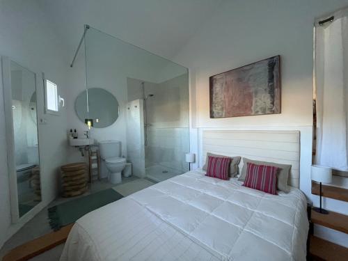 ein Schlafzimmer mit einem großen weißen Bett mit zwei Kissen in der Unterkunft House in the Mountains of Toledo in San Pablo de los Montes